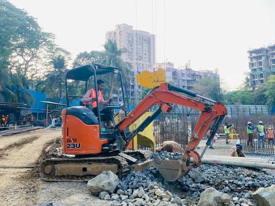 Mini excavator digging foundation area at residential project in Navi Mumbai